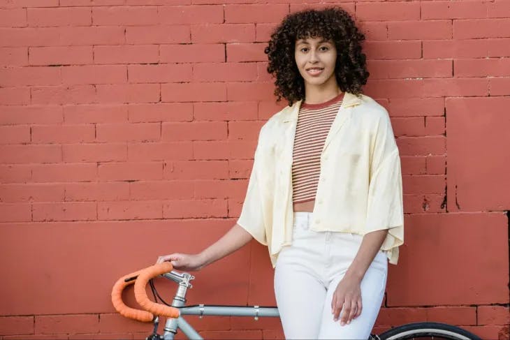 enneagram 9 female standing next to a bike