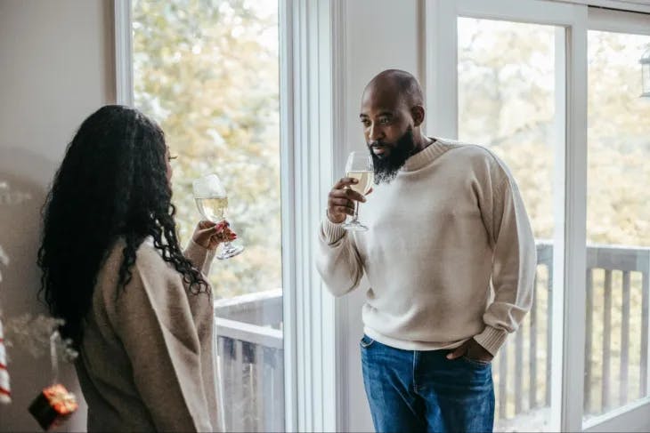 A man and woman having a conversation over a glass of white wine