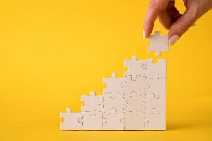Puzzle pieces arranged on a vibrant yellow background