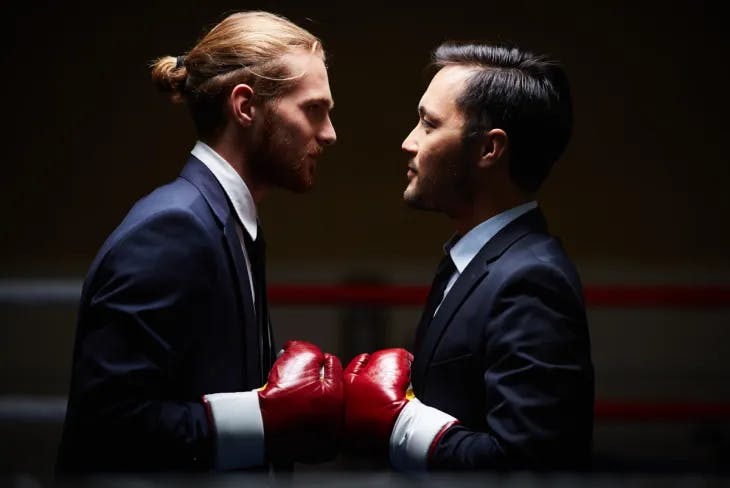 Two men in suits in a boxing faceoff