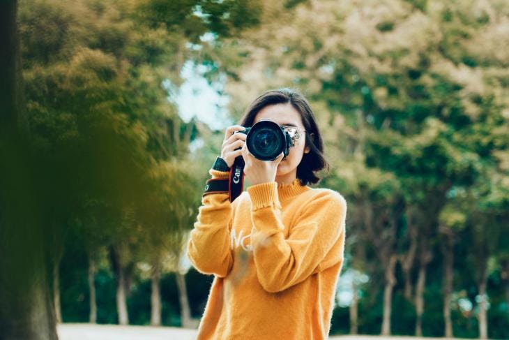 Girl in yellow outfit taking a photo