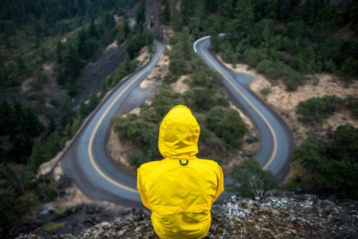 Person in a yellow raincoat facing the road