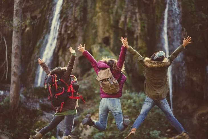 Three people jumping on a hike