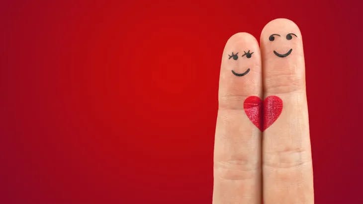 Two finger-drawn faces sharing a heart