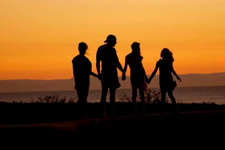 Four silhouettes holding hands