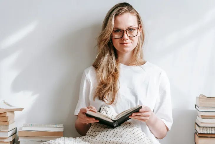 Woman in glasses surrounded by books