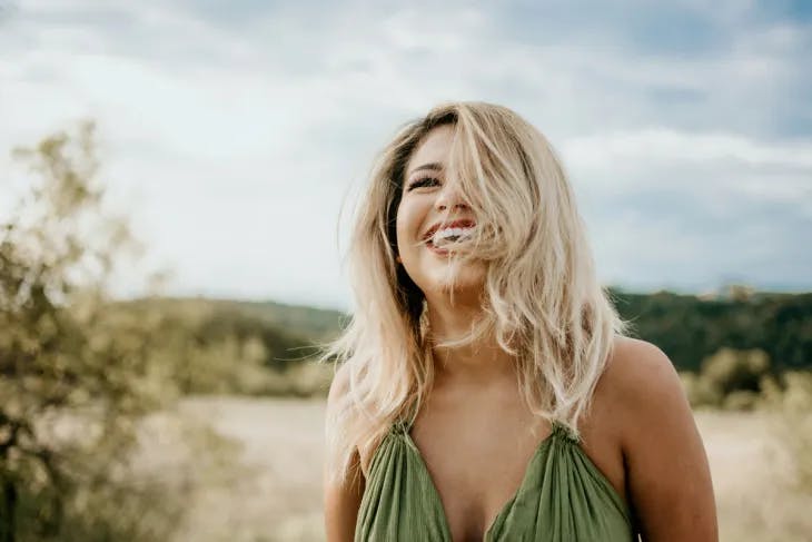 Smiling blonde woman wearing a green dress