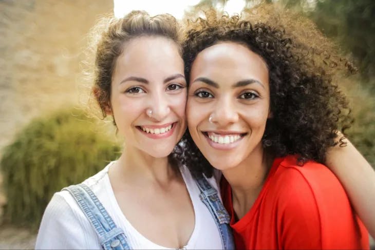 Two females smiling - enneagram 6 and 8 misidentification