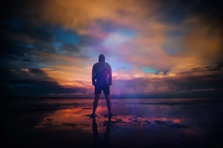 Man standing on the shore after sunset