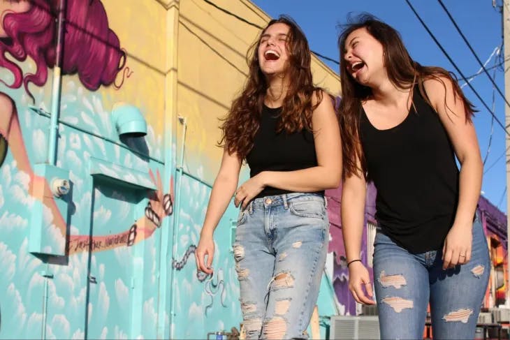 Two girls walking and laughing