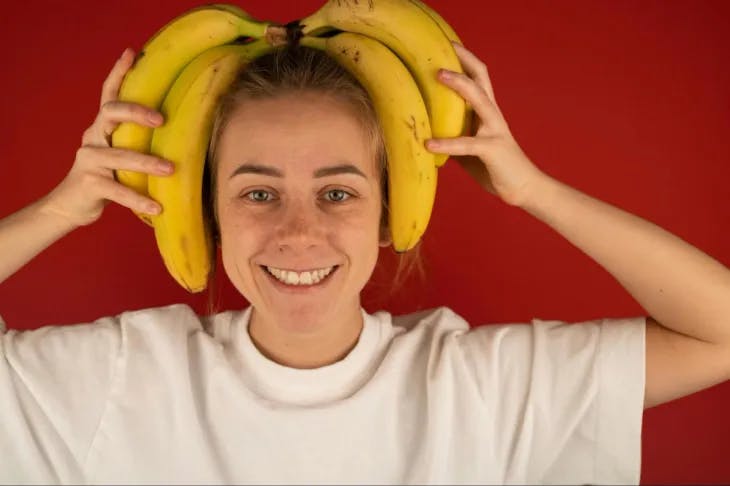 A woman stacking bananas on her head