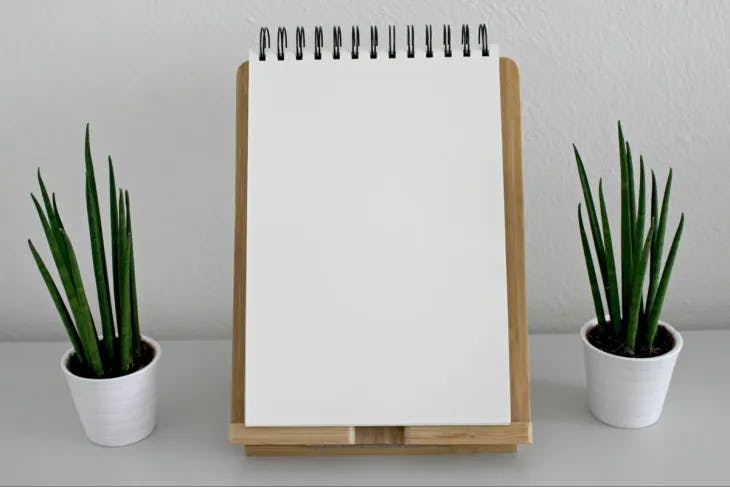 A notebook on a stand with two plant pots on either side