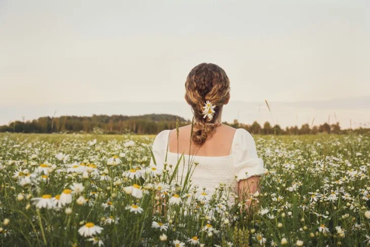 Woman stands amidst a picturesque flower field