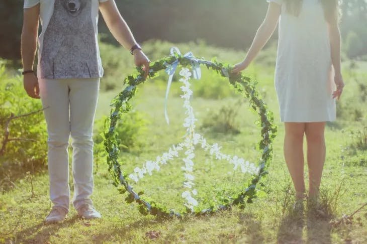 Boy and girl holding a peace sign made from flowers